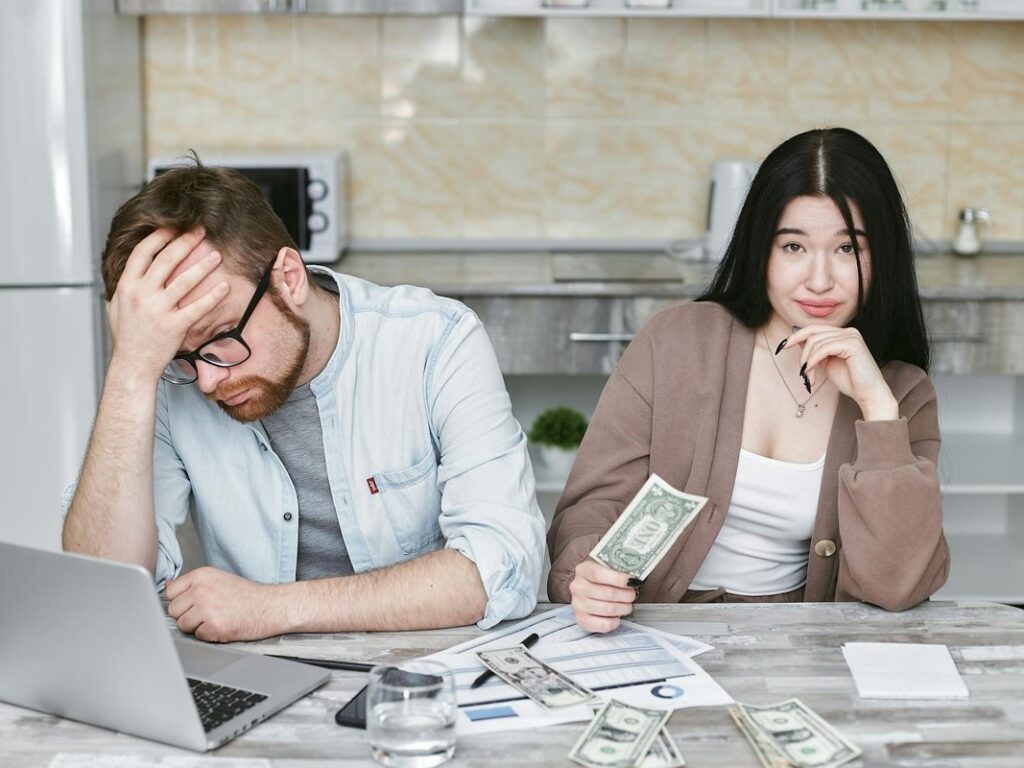A couple with a lawyer in an office setting, reviewing divorce documents in formal attire.