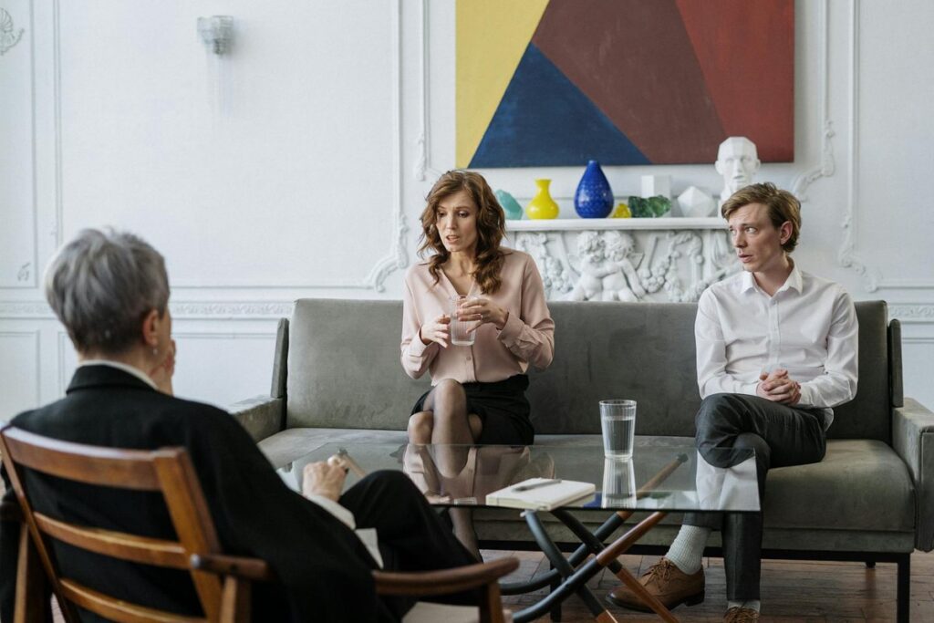 A couple conversing with a therapist in a chic, modern office setting.
