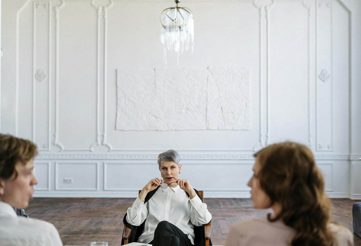 A therapist guiding a couple through a counseling session in an elegant office setting.