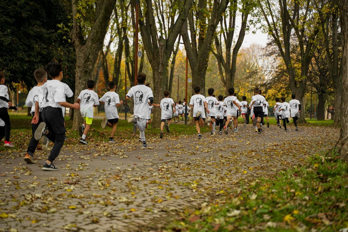 A group of kids participating in a running event in a leafy park in Bursa, Türkiye.