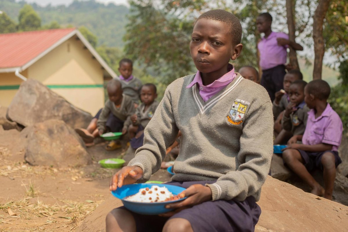 Children enjoying their meal outside, highlighting school life and nourishment.