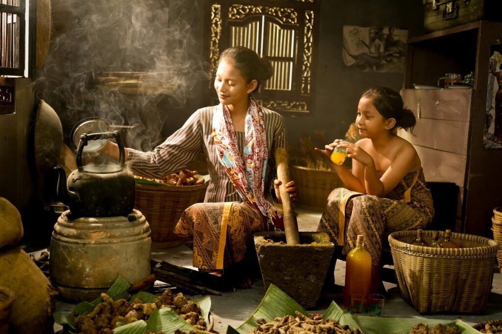 Indonesian mother and child in a traditional kitchen setting preparing herbs and drinks.
