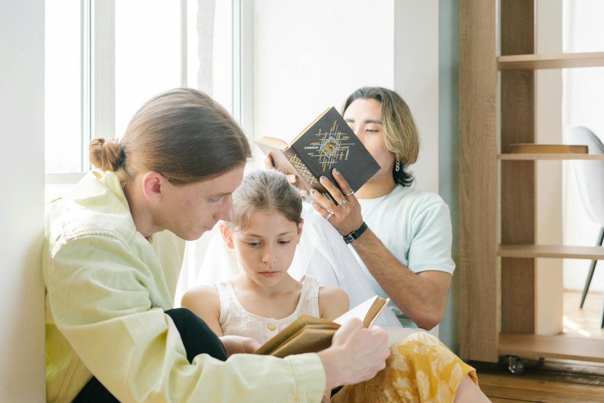 A diverse family bonding through reading together with natural light indoors.
