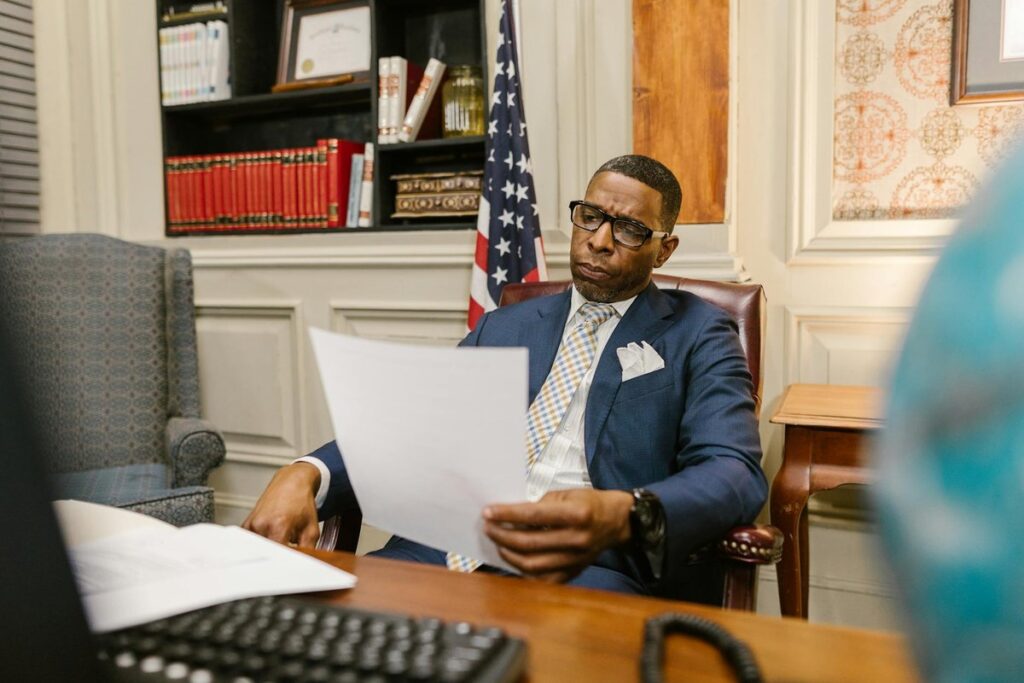 A lawyer attentively reviewing documents at his desk in a law office setting.