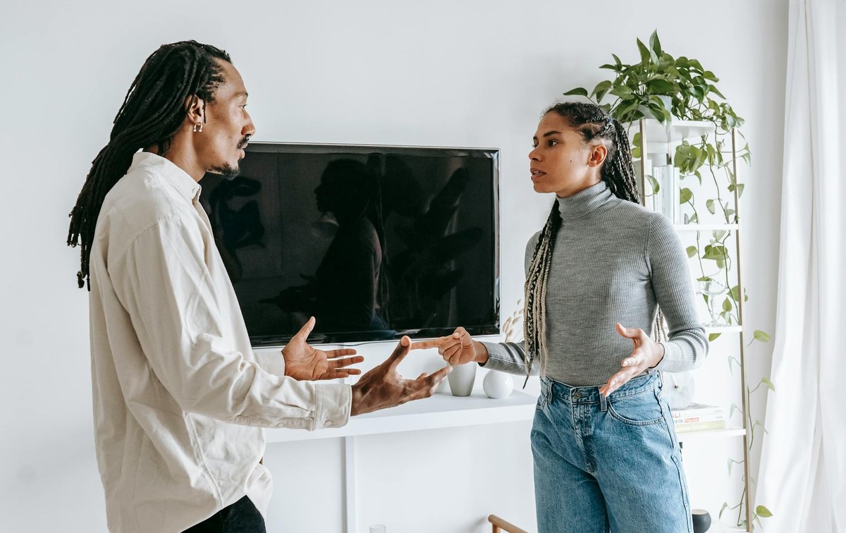 Young couple discussing relationship issues in a modern living room setting.
