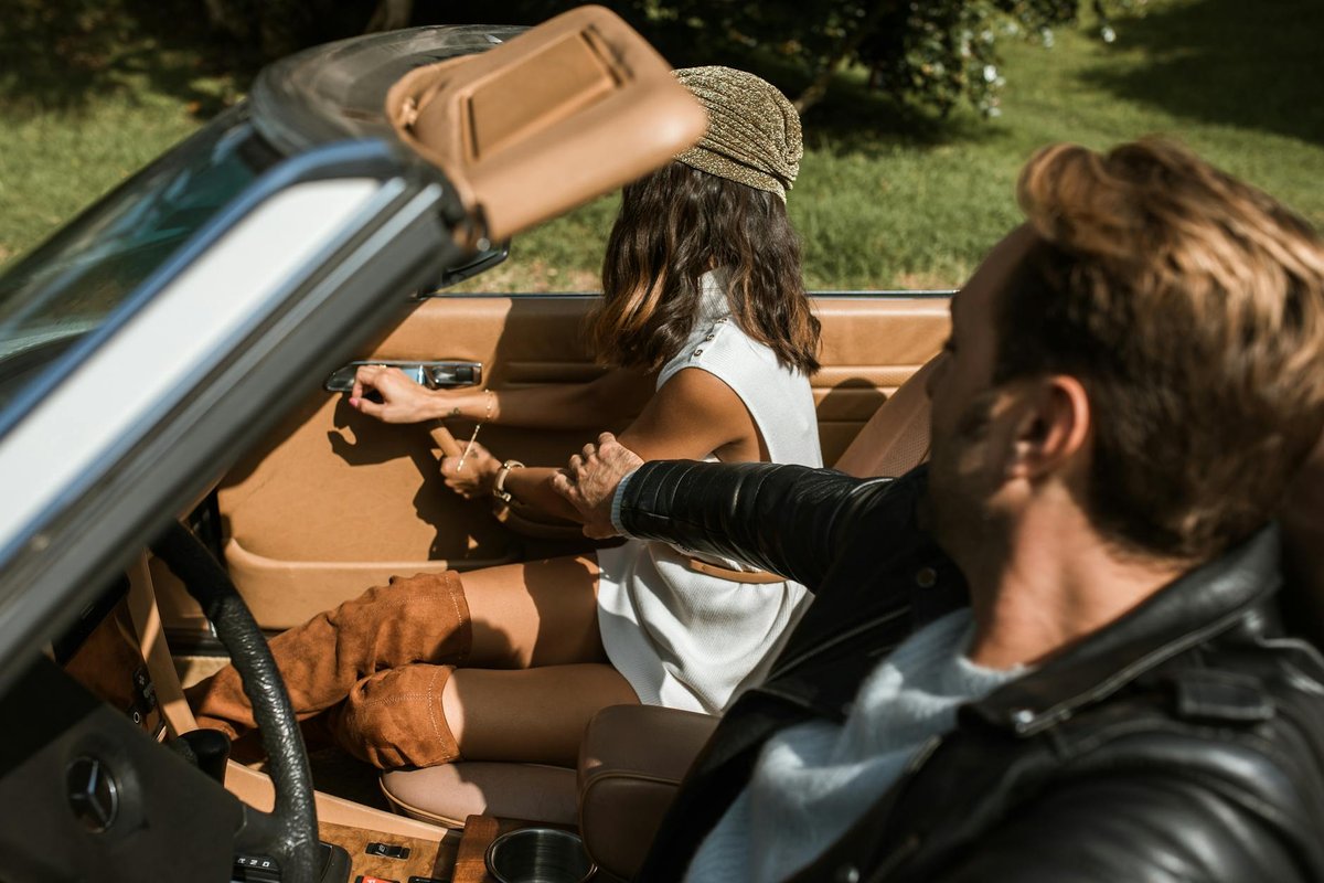 A couple having an argument in a convertible car during a summer day outdoors.