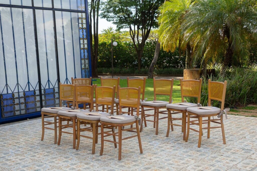 Arrangement of wooden chairs for an outdoor event in São Paulo, Brasil, under palm trees.