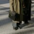 Two business professionals in coats walking with briefcases in an urban setting.