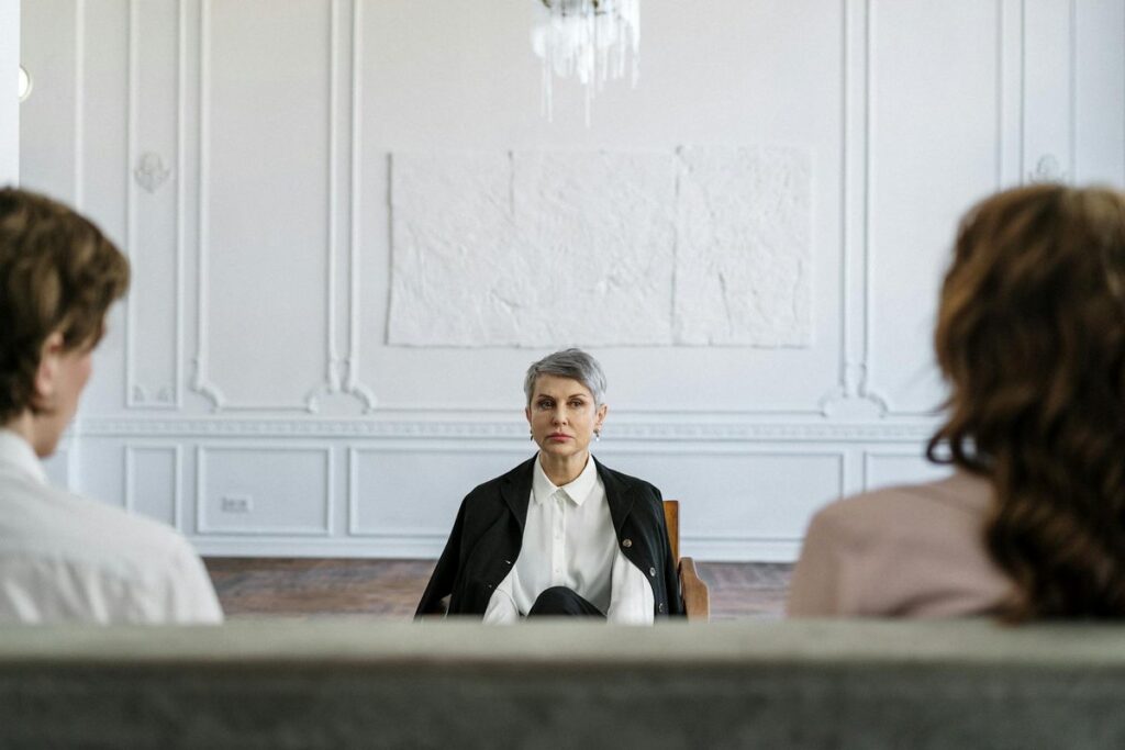 A married couple in a consulting session with a therapist in a modern, minimalistic office.