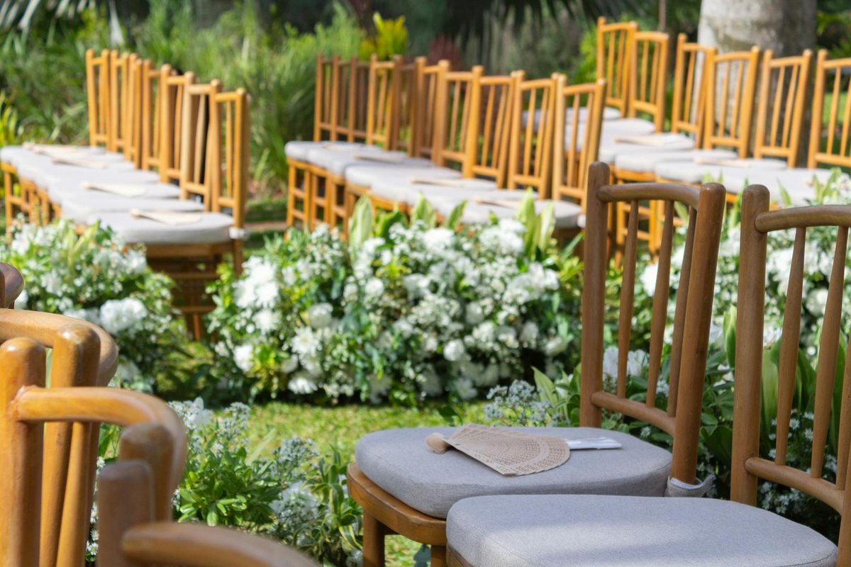 Charming outdoor wedding setup in São Paulo with wooden chairs and floral arrangements.
