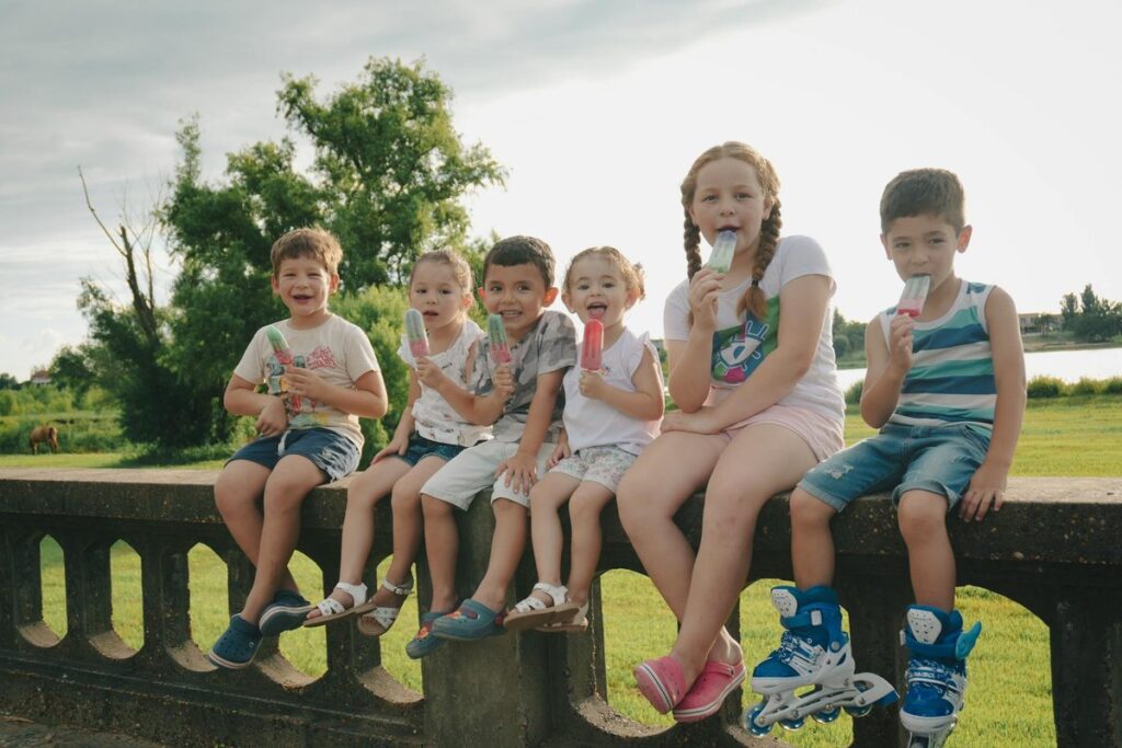 Group of children savoring colorful popsicles on a warm summer day in Entre Ríos, Argentina.