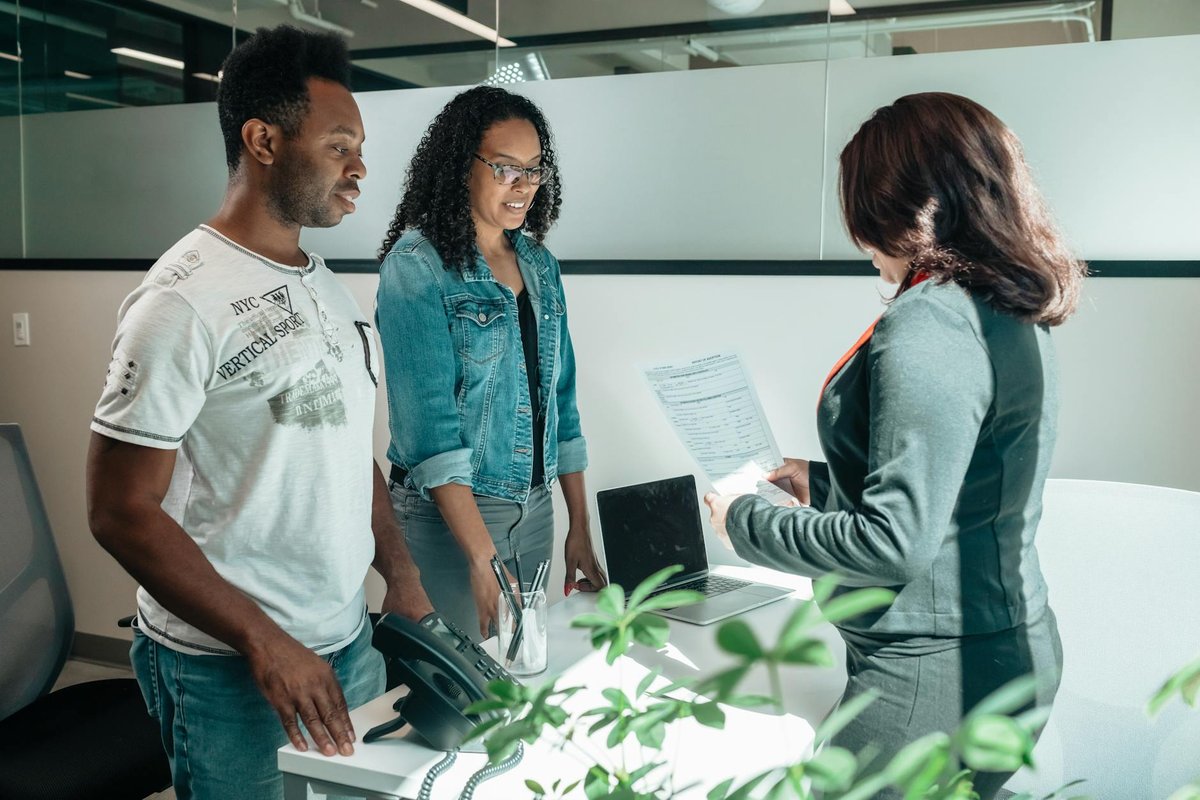 A diverse group in a business meeting discussing documents in a modern office setting.