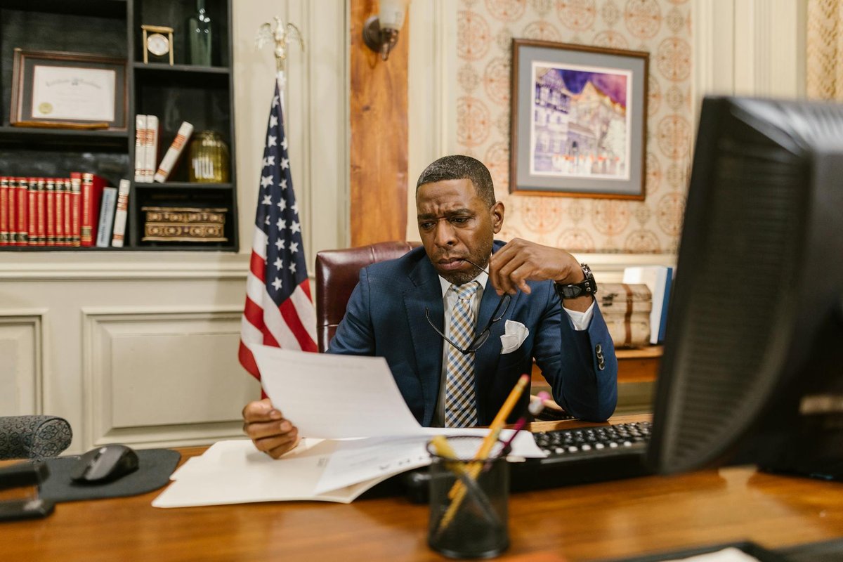 A focused lawyer reading documents in an office, symbolizing professionalism and legal expertise.