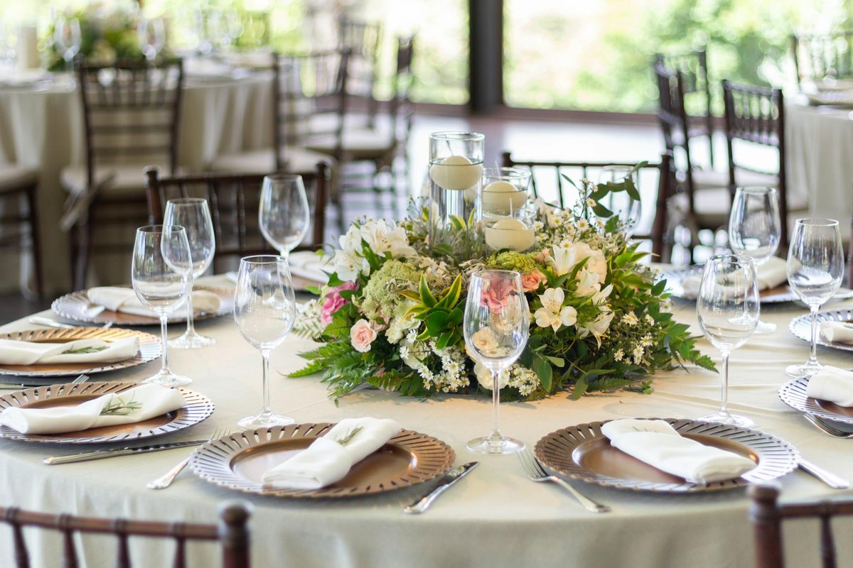 Chic wedding table setting with elaborate floral centerpiece and fine tableware, perfect for sophisticated events.