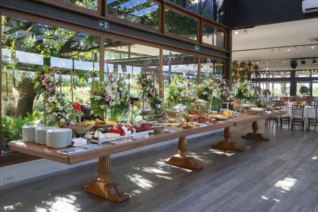 An elegant indoor buffet in São Paulo featuring floral arrangements and assorted foods for a special event.