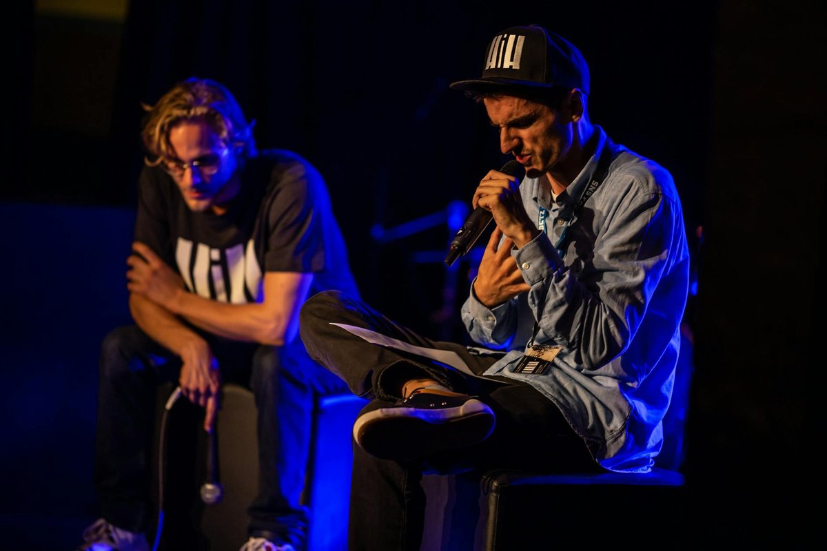 Two musicians performing energetically on stage under bright lights in Glarus, Switzerland.