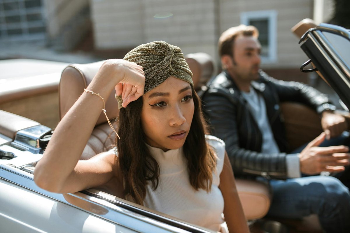 A couple having an intense discussion while seated in a convertible car.