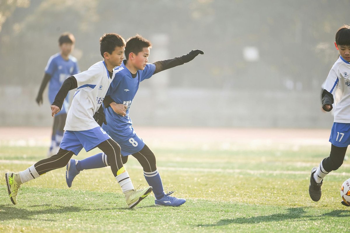 Energetic group of boys playing soccer outdoors on a sunny day, showcasing teamwork and sportsmanship.