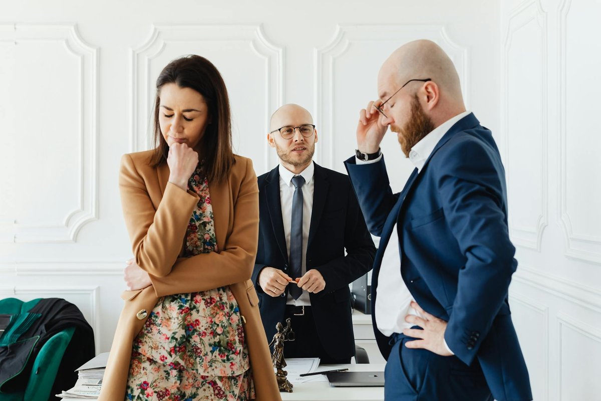 Business scenario with a couple discussing with a lawyer in a formal office.