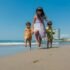 Three kids enjoy a sunny day on the beach, capturing the essence of summer fun and happiness.