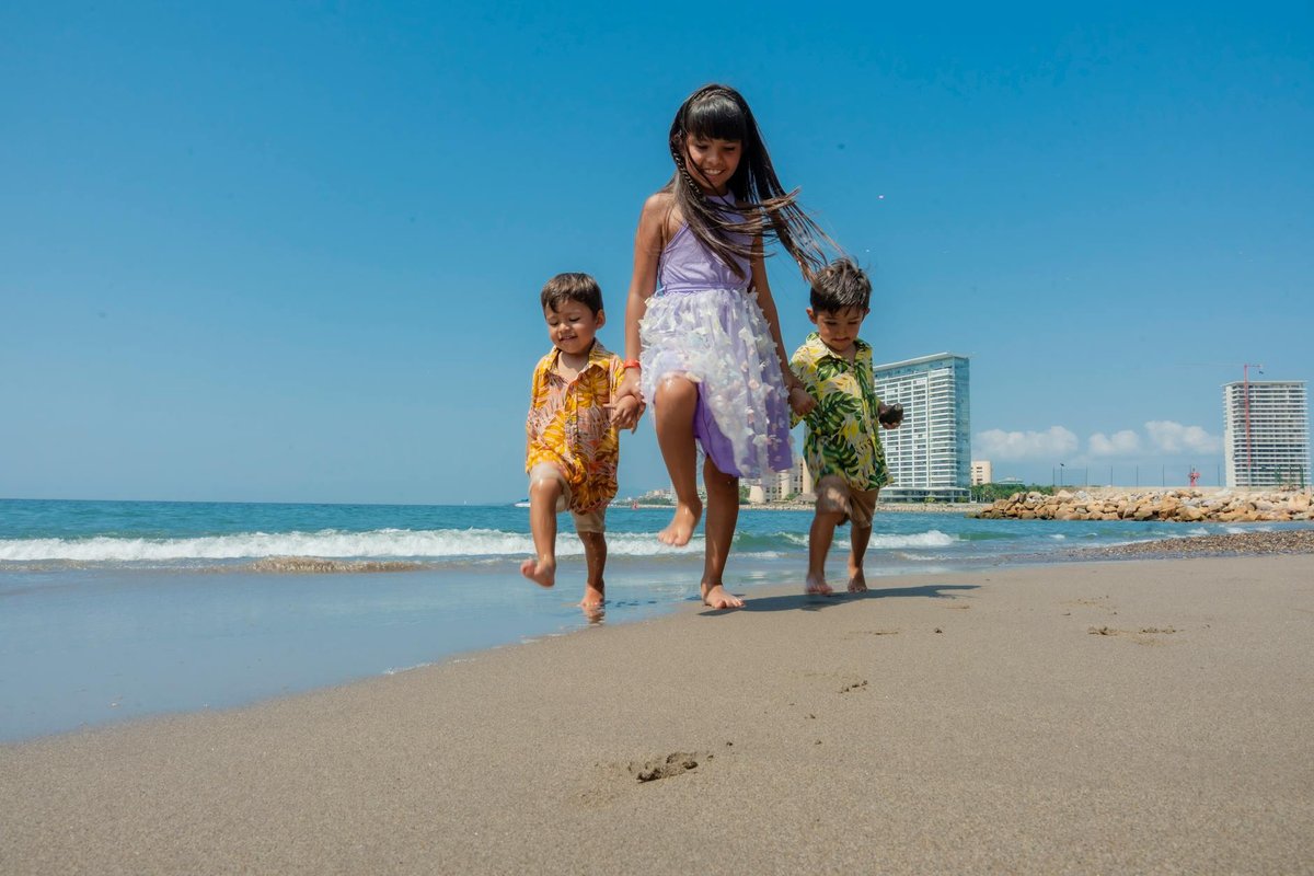 Three kids enjoy a sunny day on the beach, capturing the essence of summer fun and happiness.