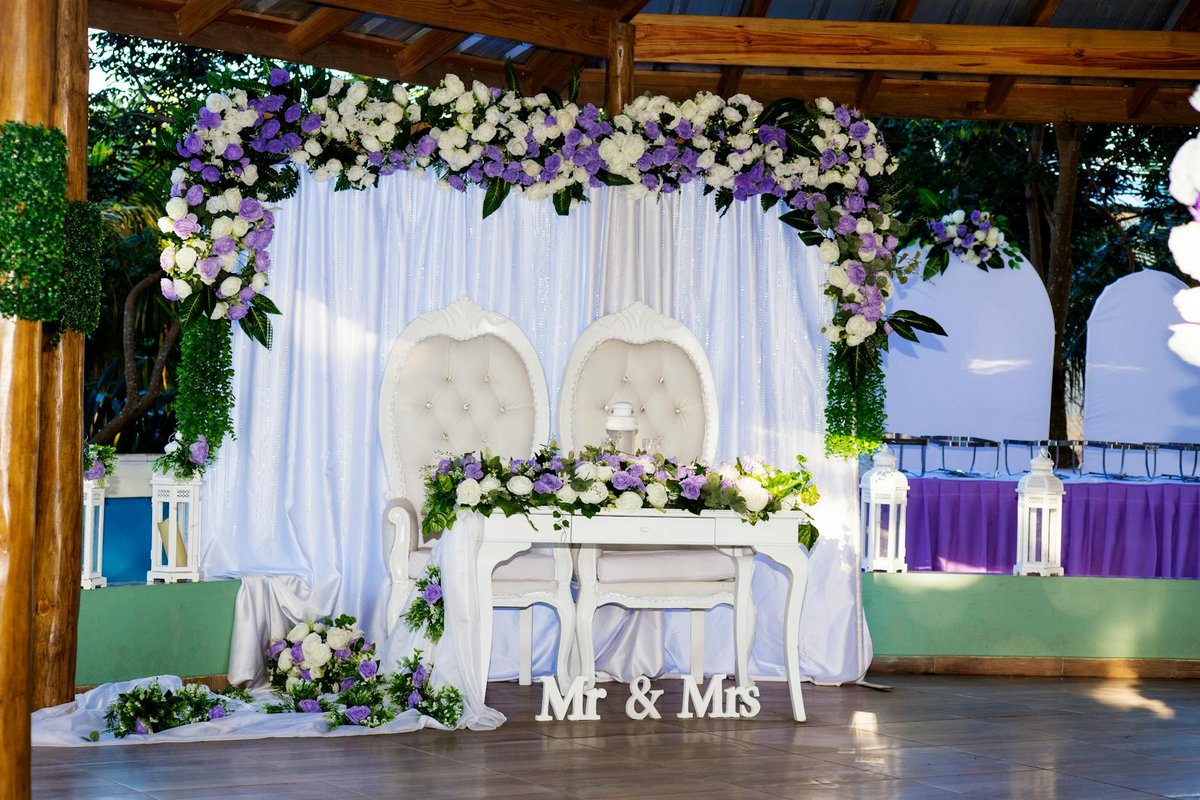 Beautifully decorated outdoor wedding venue with floral arches and chairs.