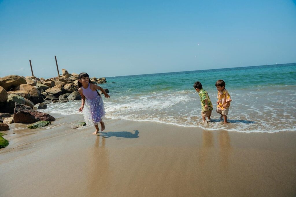 Joyful children playing by the sea on a sunny day, capturing carefree summer fun.