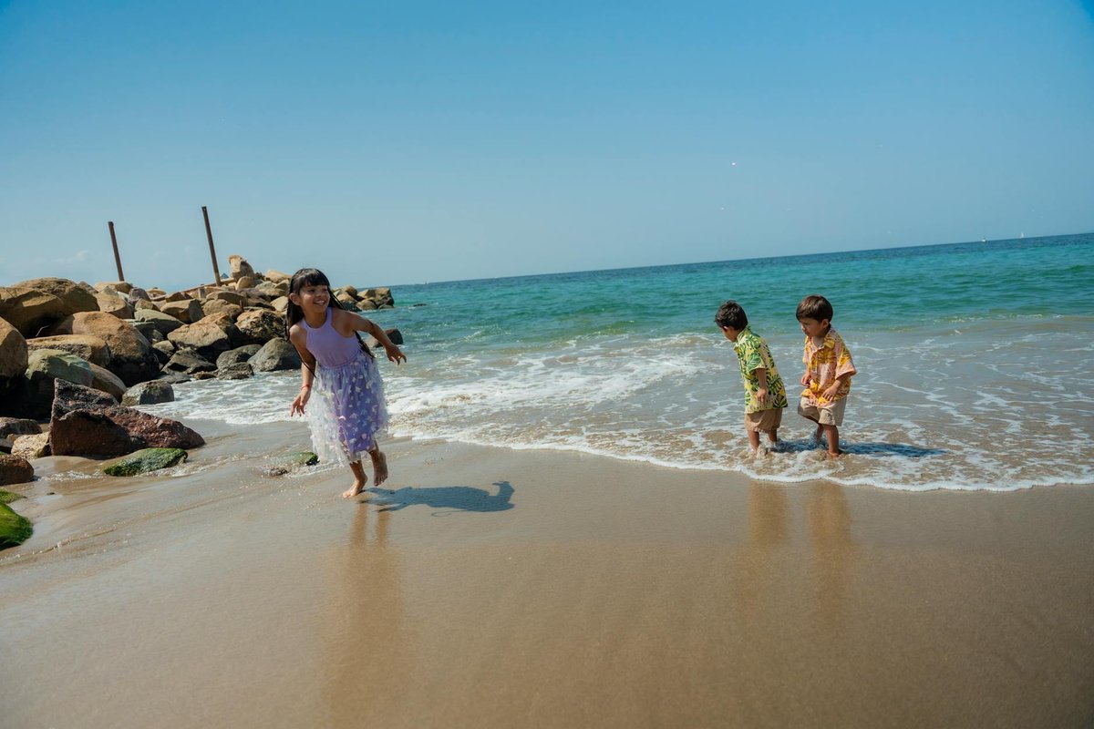 Joyful children playing by the sea on a sunny day, capturing carefree summer fun.