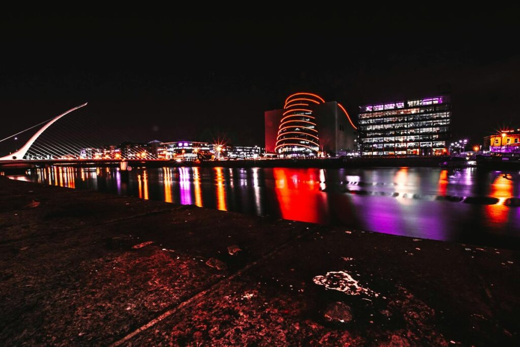 A stunning night scene capturing the illuminated Dublin cityscape with reflections on the river.