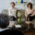 A couple sits on a sofa during a therapy session with a counselor, focusing on relationship issues.
