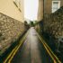 A narrow deserted alleyway in Dublin, with wet stone walls and a street sign.