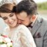 Bride and groom celebrating love outdoors, wearing elegant attire and joyful smiles.