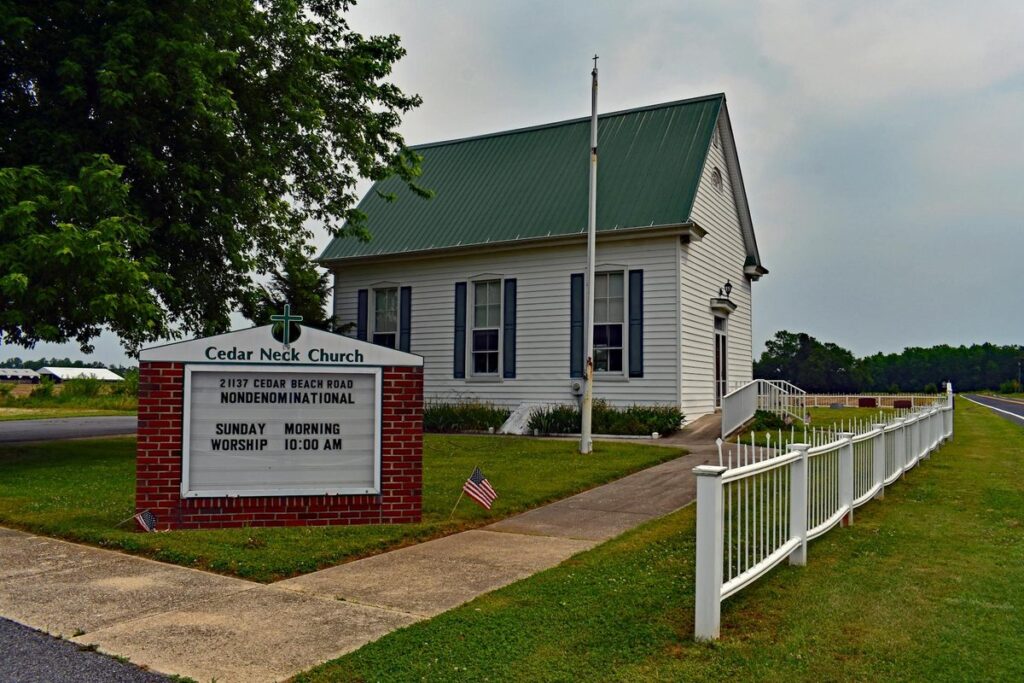 Nondenominational Cedar Neck Church with green roof, photographed on a cloudy day in Delaware.