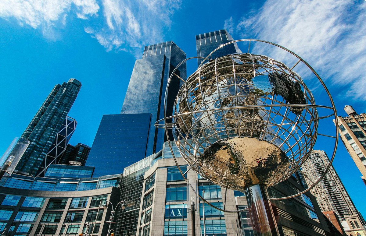 Captivating view of New York City skyline featuring a prominent globe sculpture and tall skyscrapers.
