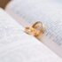 Close-up of wedding rings resting on the pages of an open book, symbolizing love and commitment.