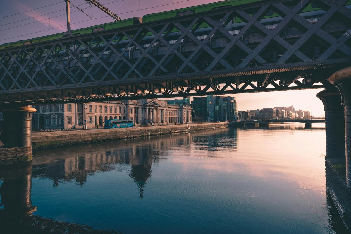 Serene view of Dublin's bridge reflecting on River Liffey at sunset.