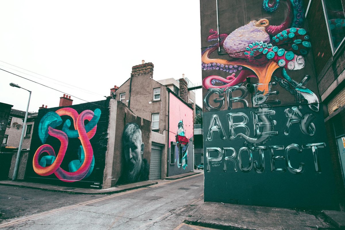 Colorful graffiti art in Dublin's alleyway, featuring abstract designs and cultural murals.