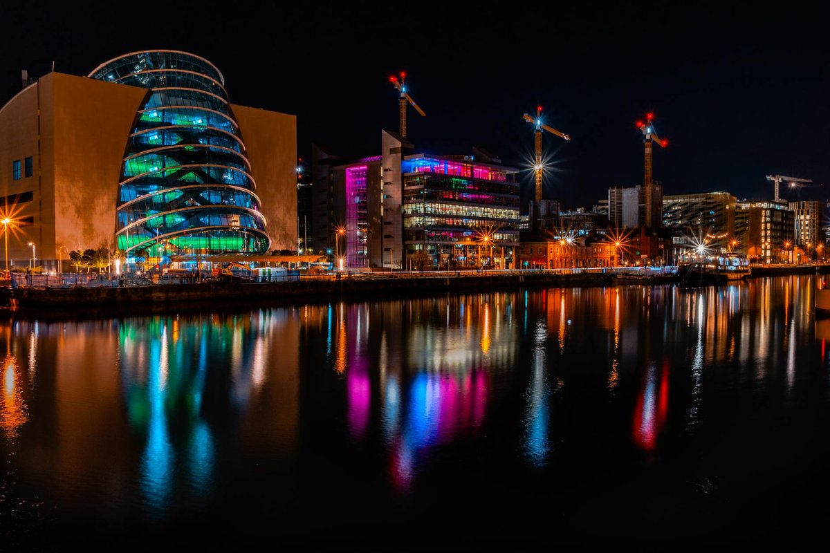 Vibrant night view of Dublin's skyline with colorful reflections on the river.