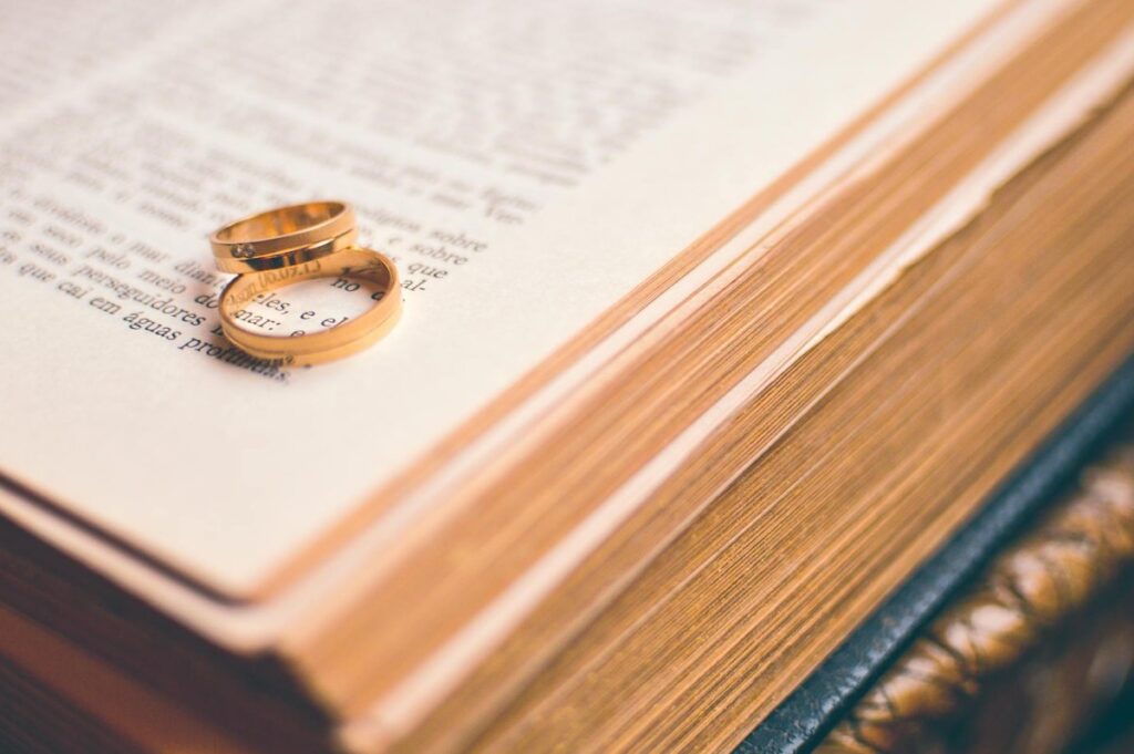 Close-up of golden wedding rings on an open book symbolizing love and commitment.