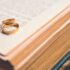 Close-up of golden wedding rings on an open book symbolizing love and commitment.