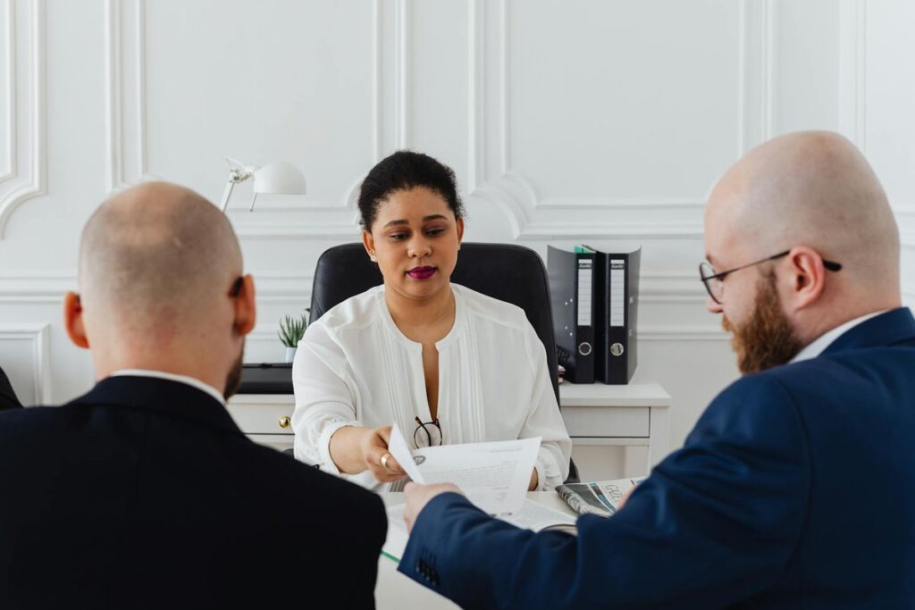 Business professionals in a serious meeting handing over a document.
