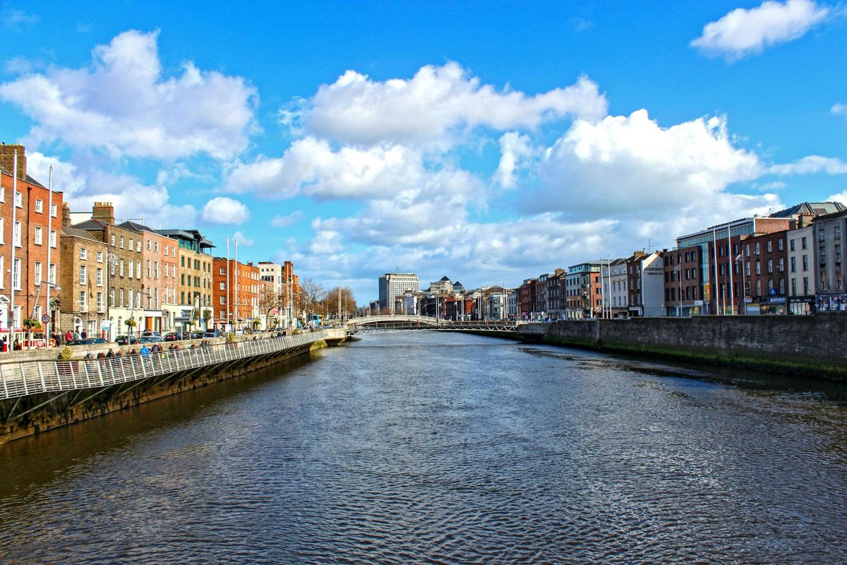 Beautiful daytime view of the River Liffey flowing through Dublin, Ireland, with iconic city buildings.