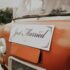 Close-up of a vintage van with a Just Married sign, symbolizing a joyful wedding celebration outdoors.