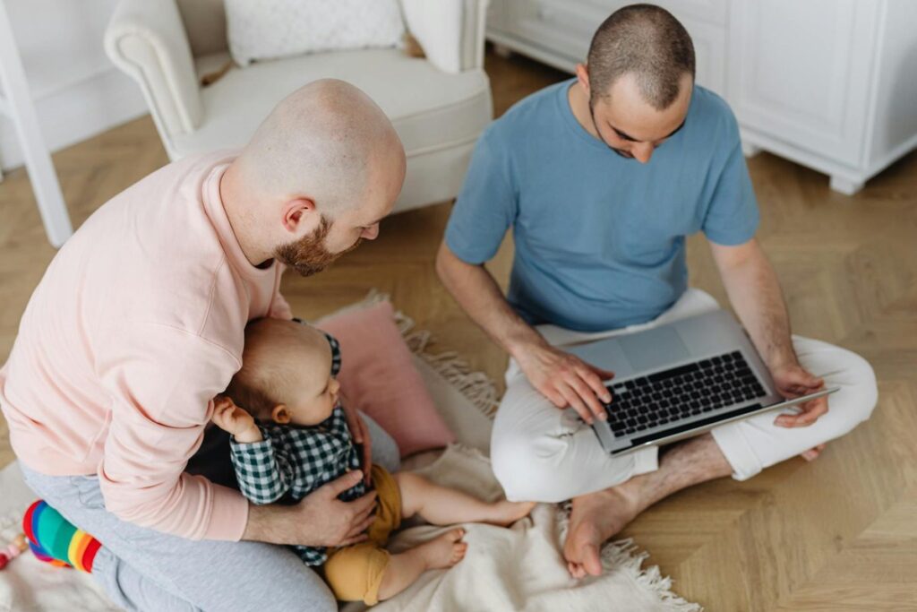 A happy same-sex couple with their child enjoying family time together indoors.