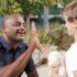 Police officer and child high-fiving outdoors, symbolizing community engagement.