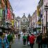 A bustling street scene in Dublin, showcasing diverse people and historic architecture.