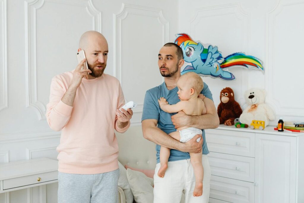 A same-sex couple with a baby at home, engaging in daily activities and conversations.
