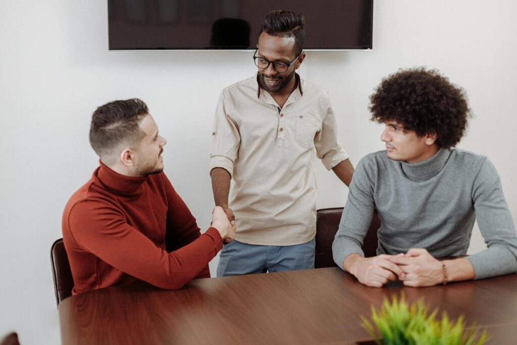 Three men in an office setting, engaging in a collaborative business discussion.