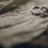 Close-up of silver wedding rings resting on crumpled paper, symbolizing commitment and marriage.