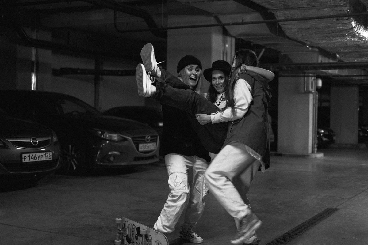 Three friends having fun together in a monochrome garage setting.